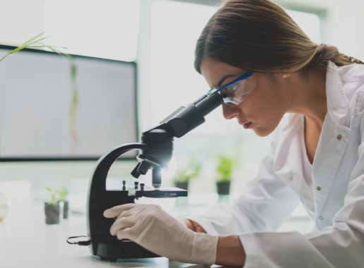 Women scientist in lab Women scientist looking through lab instrument